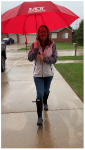 Employee holding red umbrella