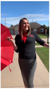 Employee dressed up holding a red umbrella